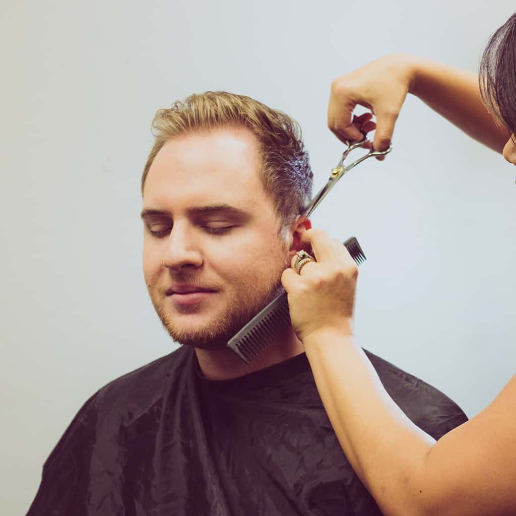 a women cutting man's hair